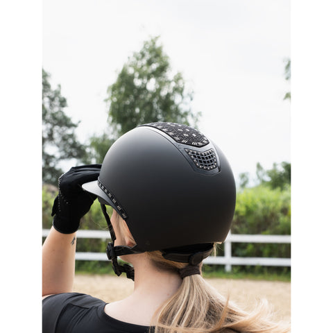 Person wearing a black helmet with decorative elements outdoors
